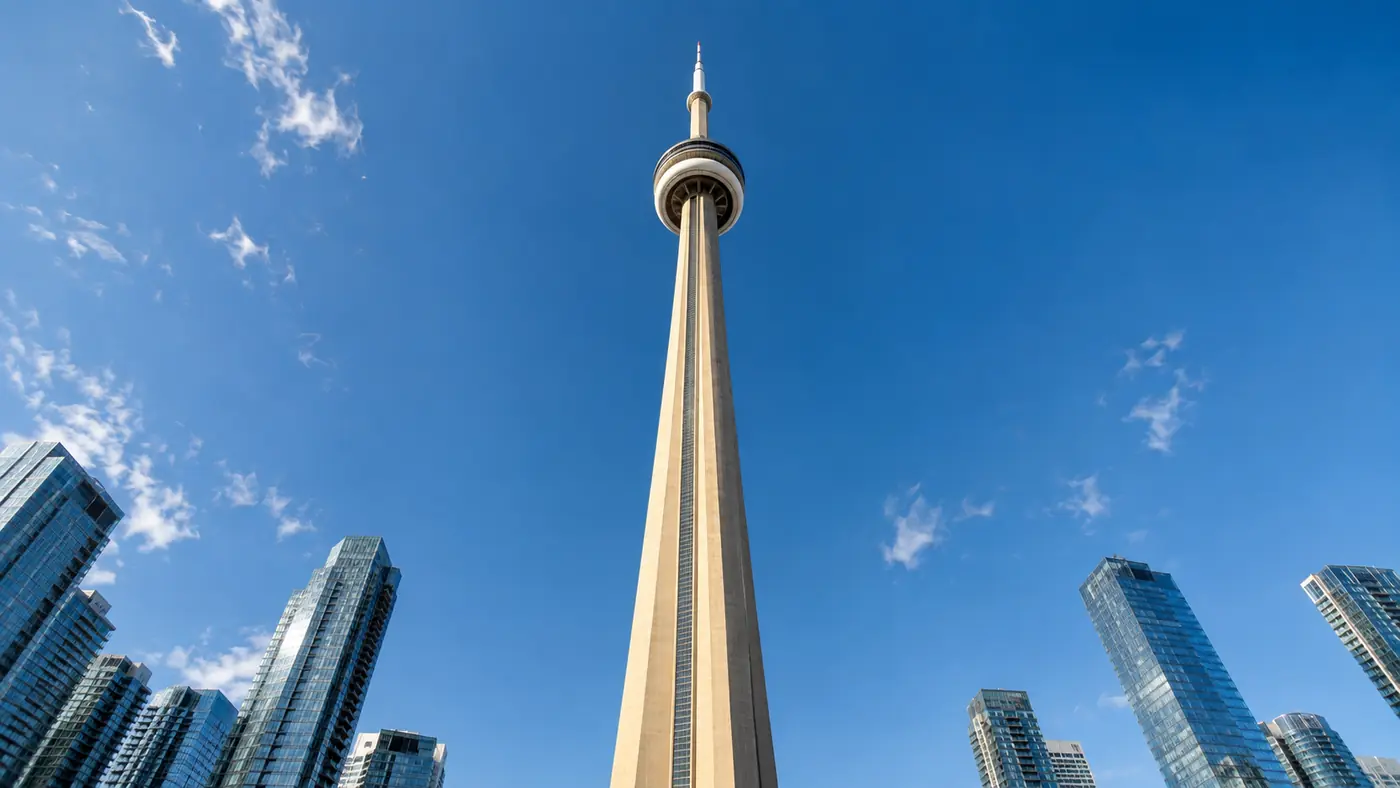 Tall slender concrete observation tower rising into a clear blue sky, photographed from near its base